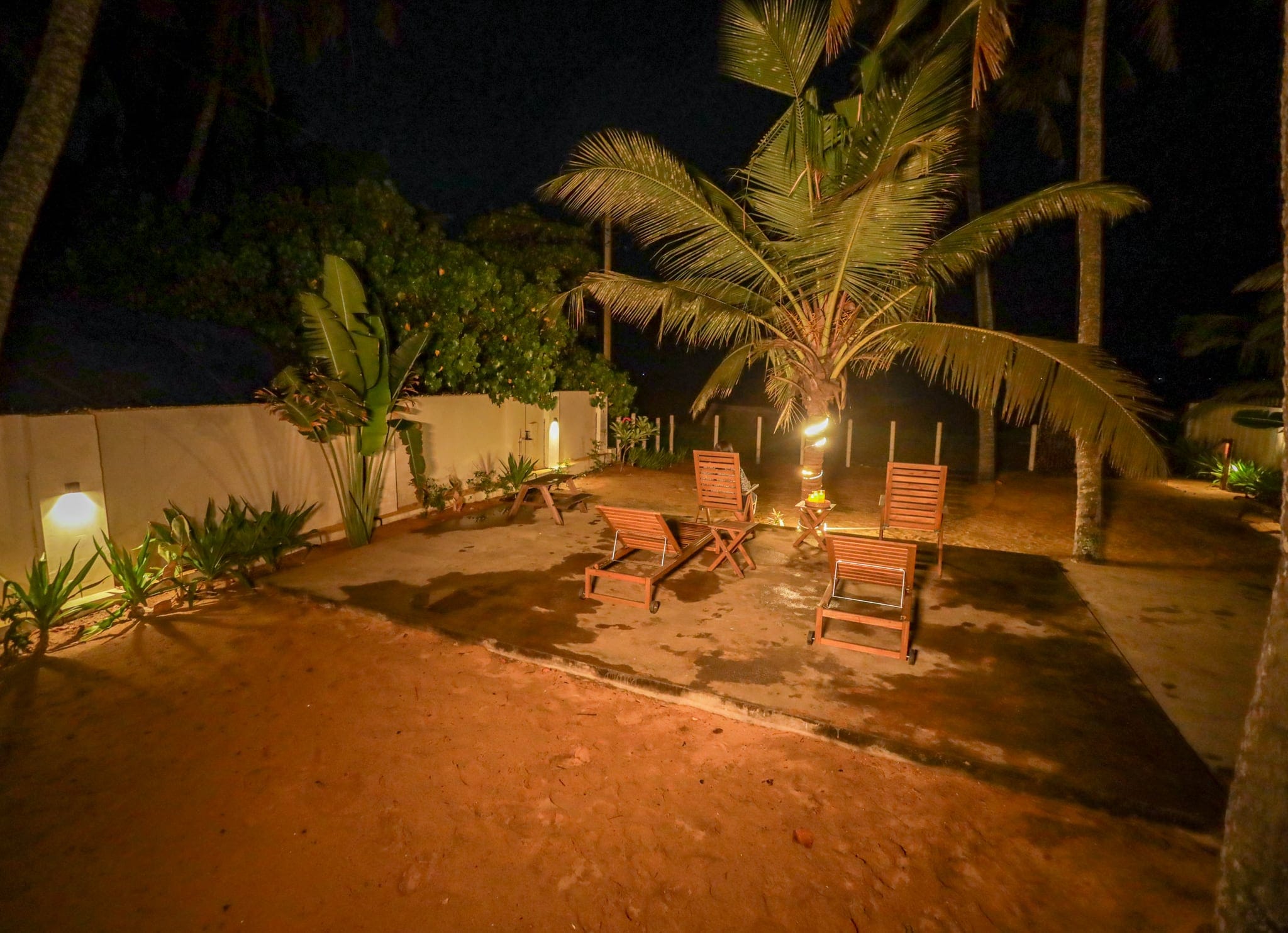 Coconut palms and a lit garden at evening at Heyday by the Sea, Veli, Thiruvananthapuram, Kerala