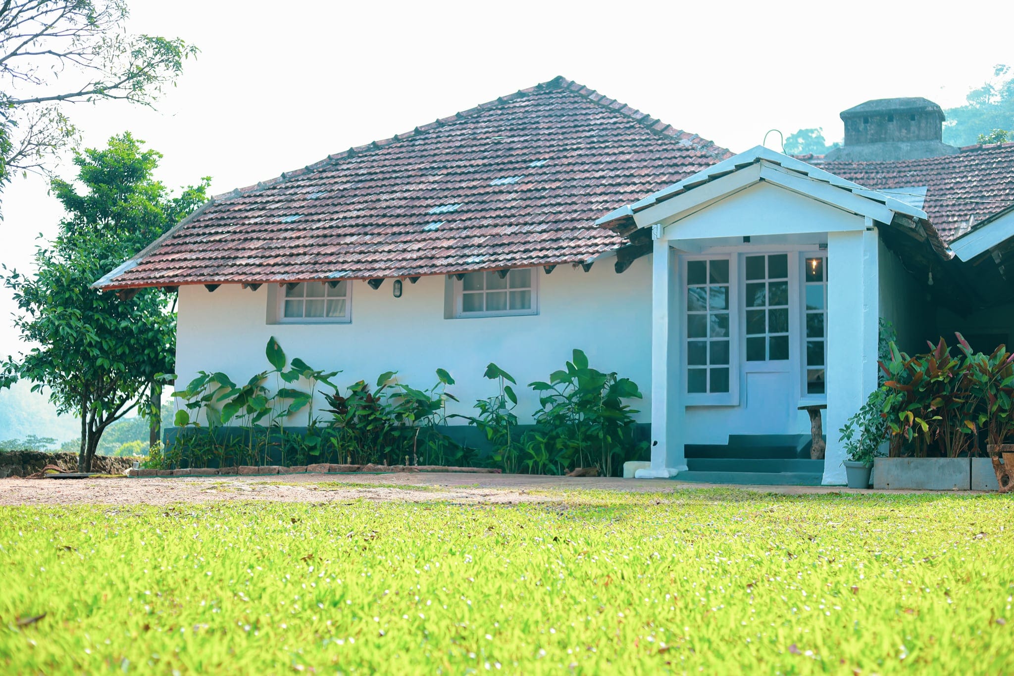 Tiled-roof 1930s planter's bungalow and lawn at Heyday Planter's Portico, near Thenmala, Kollam, Kerala